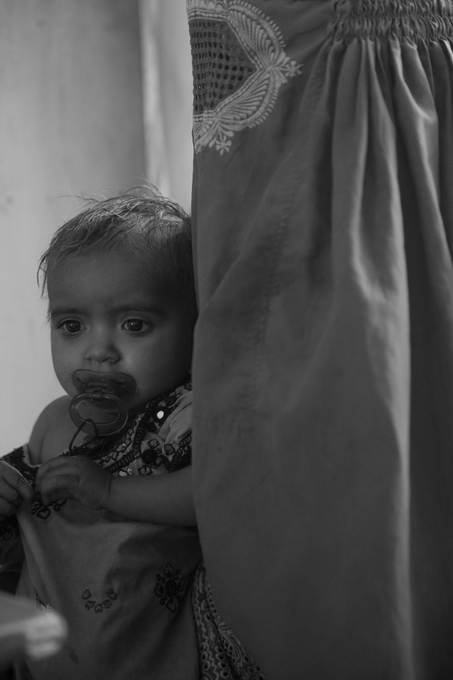 Rabail age 2 at the day care clinic with her mother who is wearing a burka | Dera Murad Jamali | MSF 